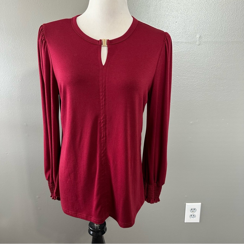 B women’s size medium‎ long sleeve blouse with gold accent at neck, maroon color